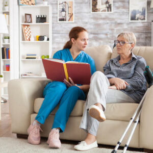 activities director reading with elderly woman