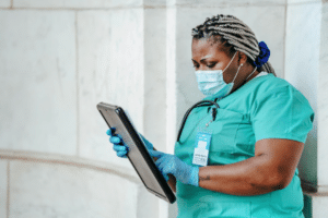 Nurse in scrubs with chart