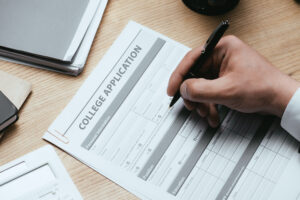 cropped view of man filling in college application College Application Deadlines: Dates and Planning Tips