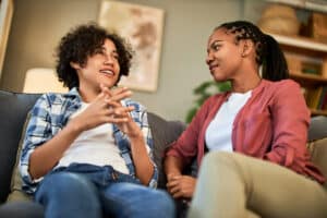 teen and adult relaxing on a grey sofa